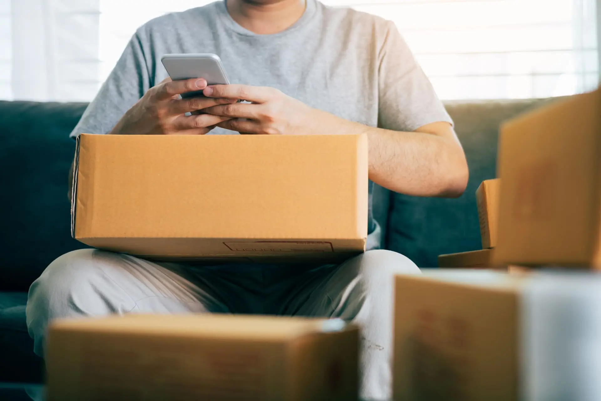Man surrounded by small boxes and holding a telephone