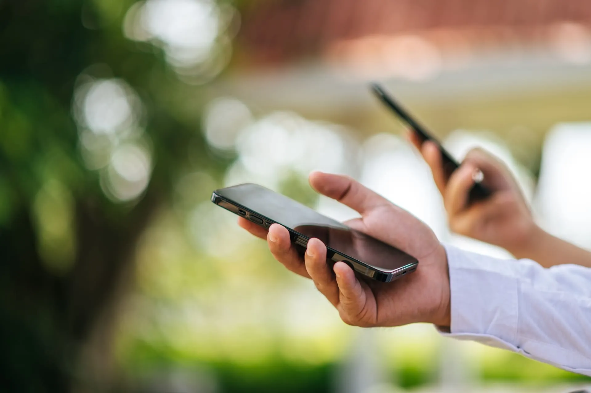 Deux personnes tenant leur téléphone dans les mains