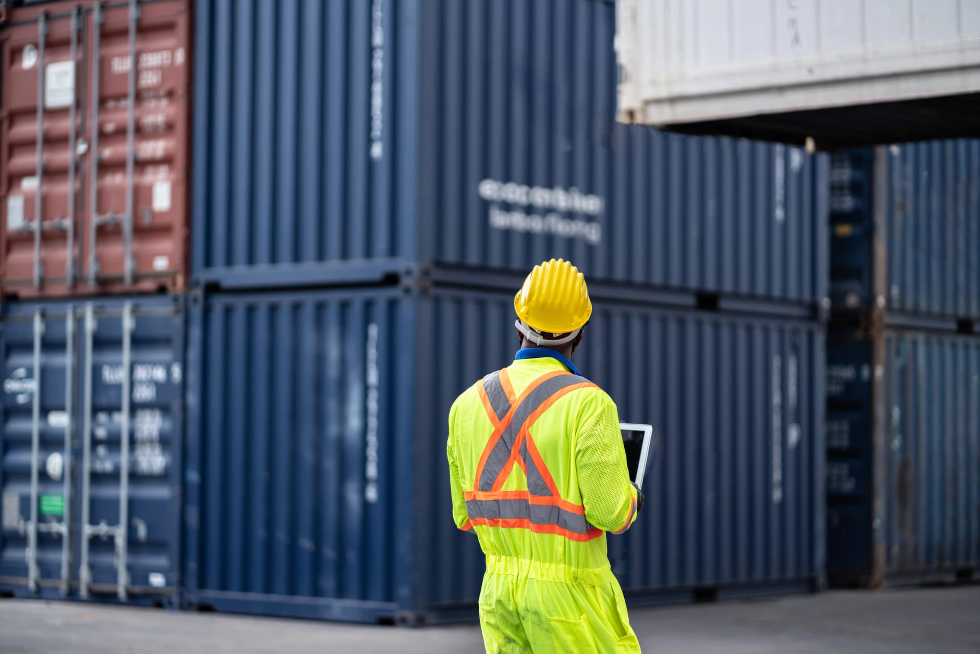 Man in work clothes surrounded by containers