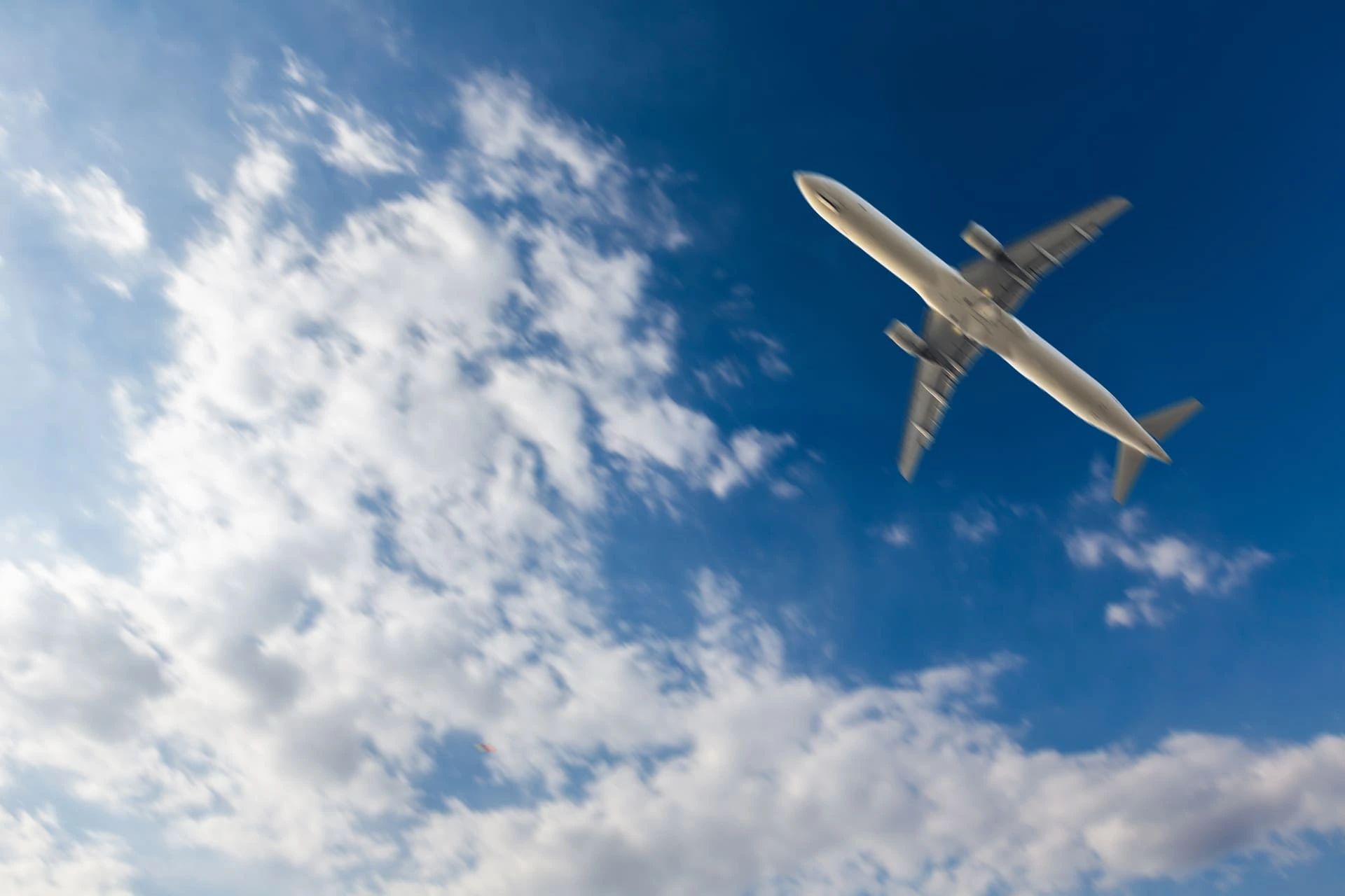 White plane in the sky, view from below