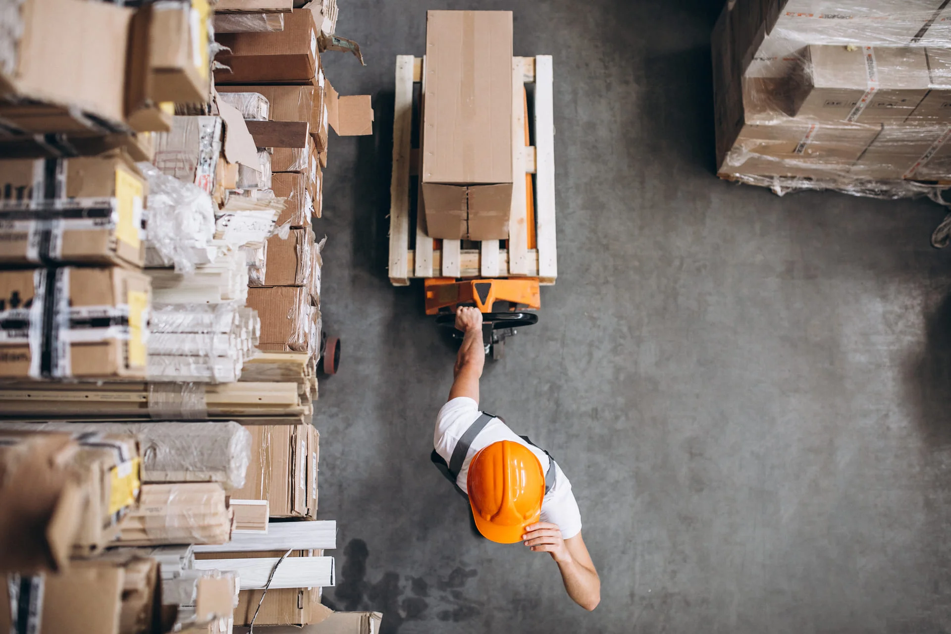 Person pulling a forklift in a warehouse