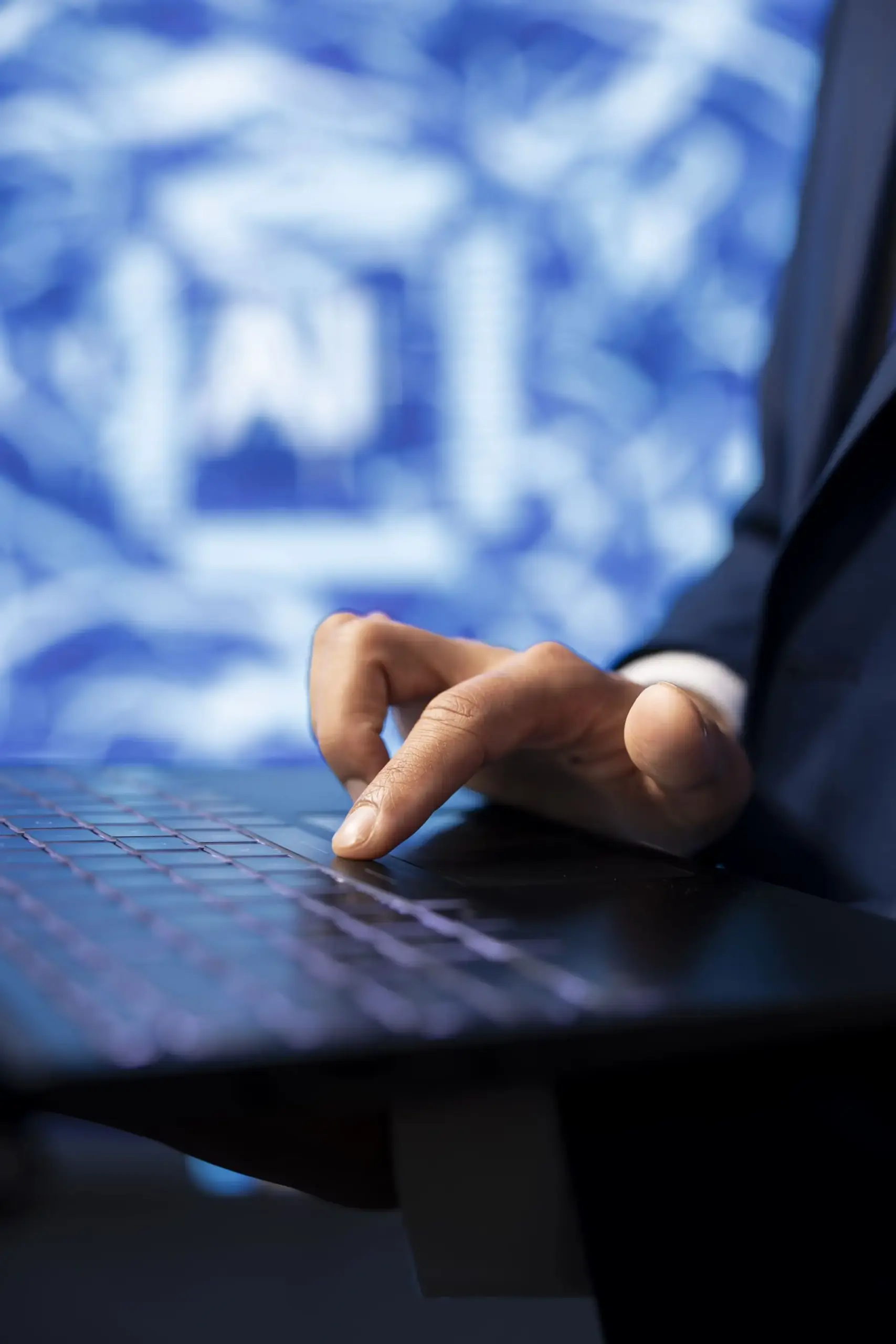 Man at his computer in front of a blue background